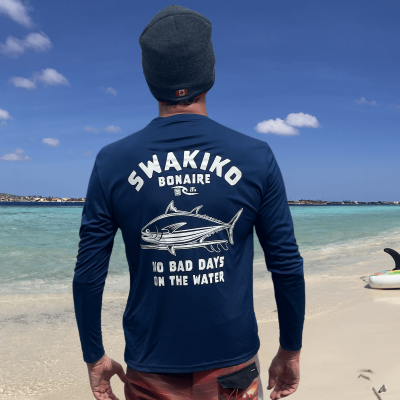 Model draagt een French Navy Swakiko surf shirt, rashguard, met print van een tonijn op een surfboard en de tekst 'No bad day