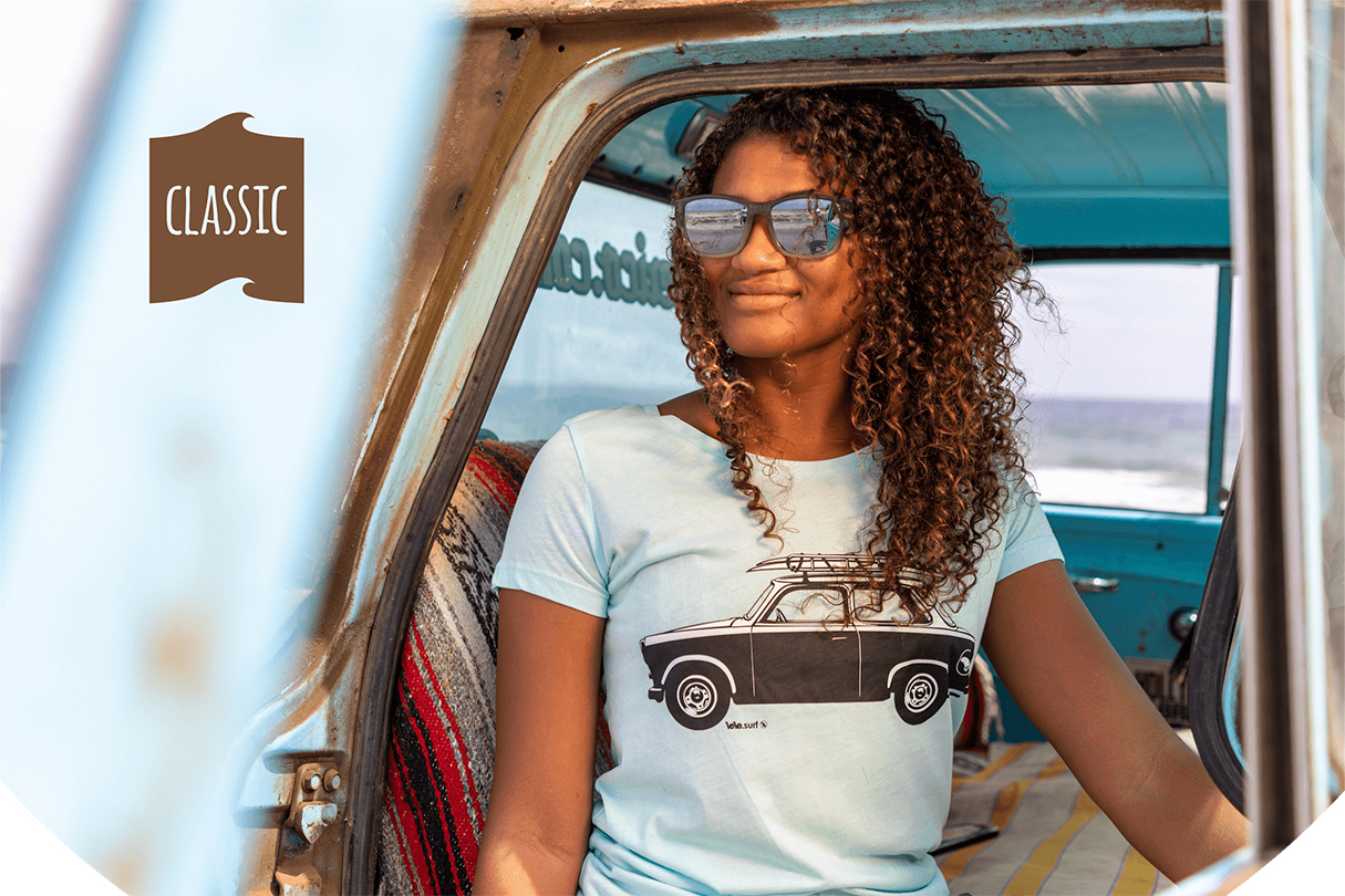 Model with the classic turquoise ladies surf shirt from the Trabant with surfboard on the roof