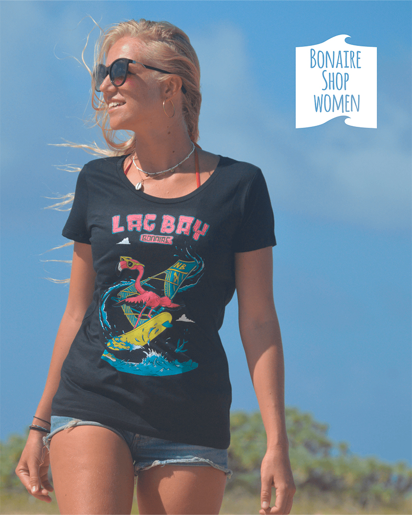 Bonaire Shop Dames: Model met zwart T-shirt van de freestyle windsurf Flamingo op surf paradijs Lac Bay bij Sorobon